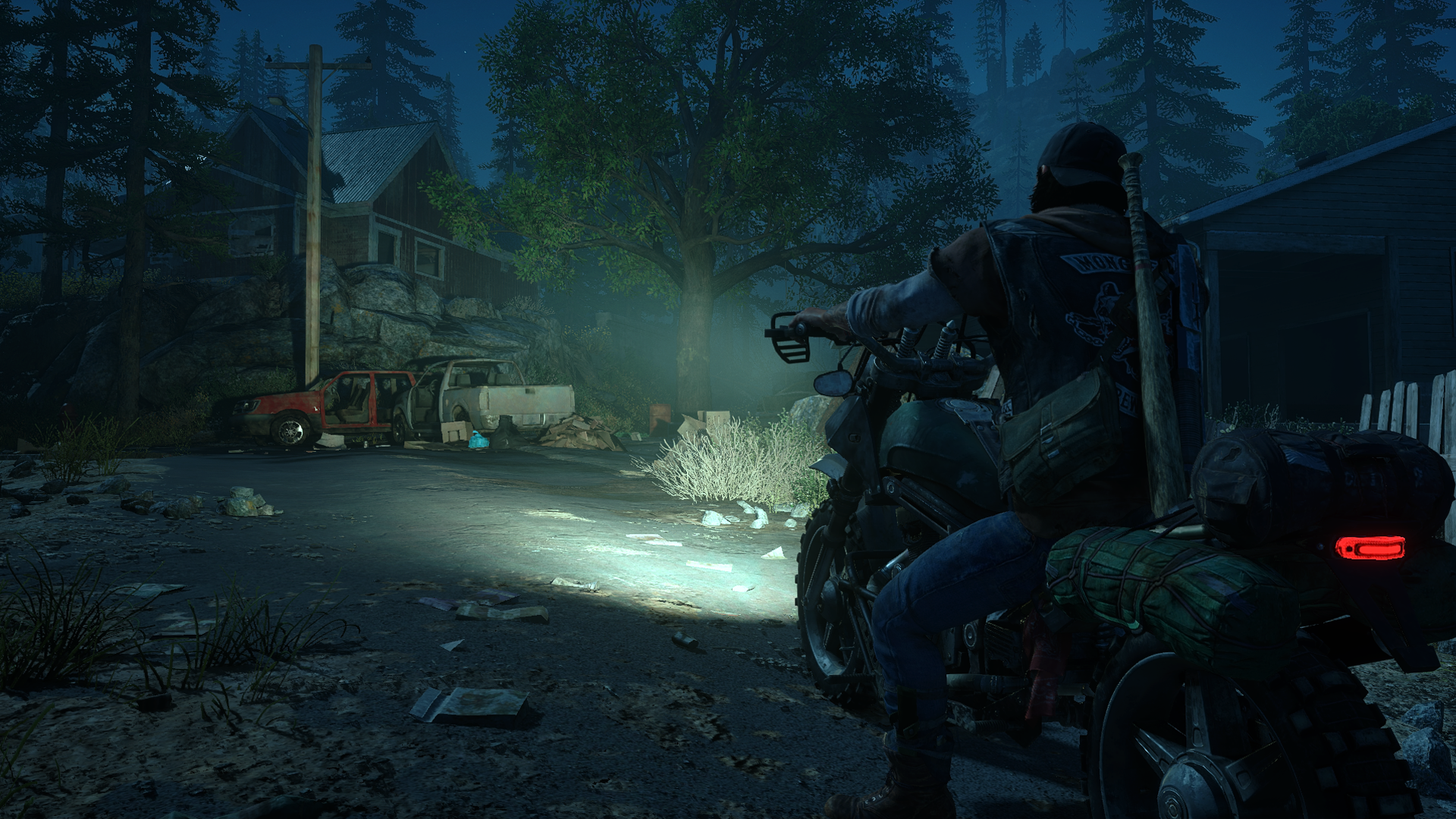 Days gone's main character deacon is sitting on his bike and looking at a house